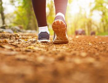 close up on a runner's feet on a dirt path