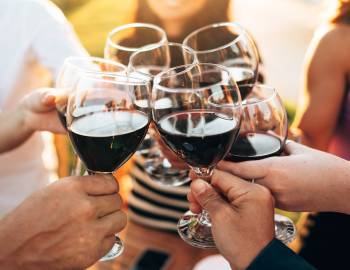 people clink wine glasses together at a festival