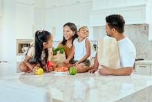 family in kitchen with groceries