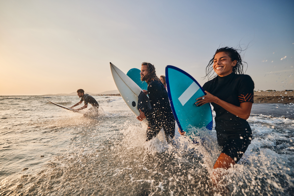 kids with surfboards running into the waves